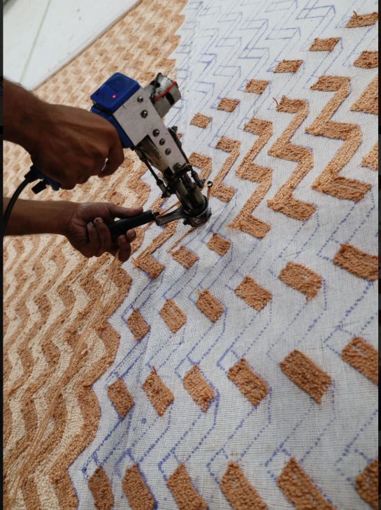 Hand-tufting in progress — the construction technique behind custom hospitality rugs